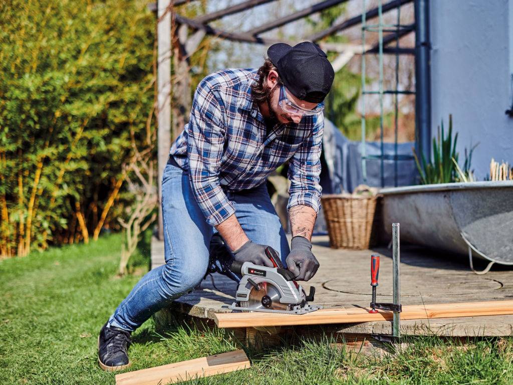 a man cuts away edge from a terrace with the hand circular saw