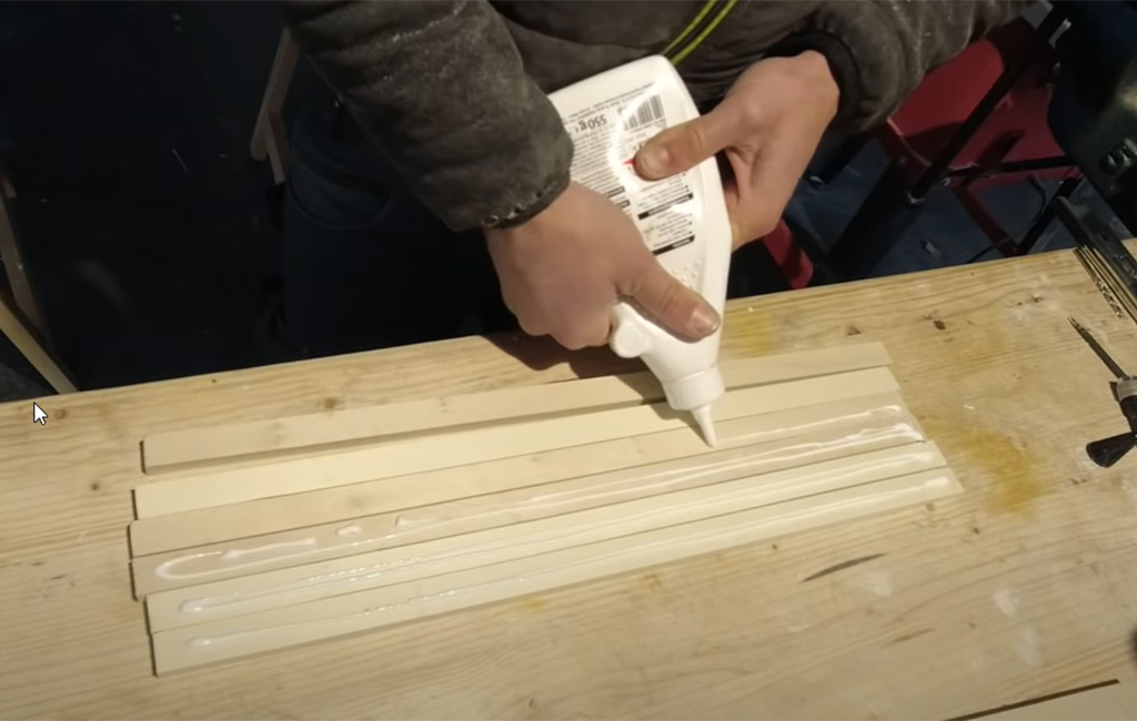 Wooden slats are laid out side by side and covered with wood glue.
