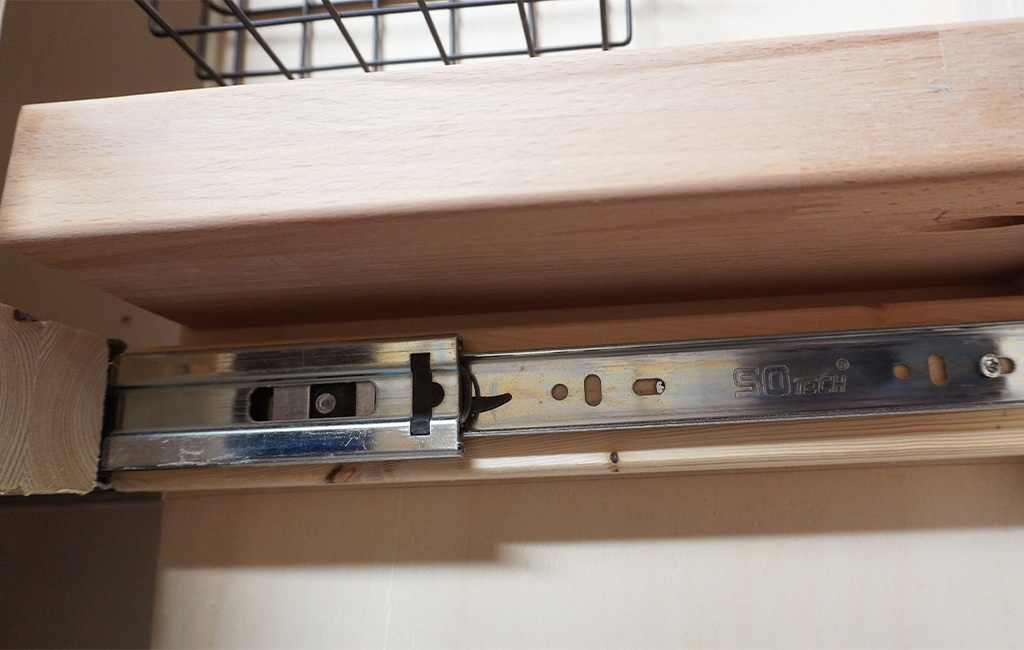 Pull-out basket in wooden frame mounted on metal drawer slide