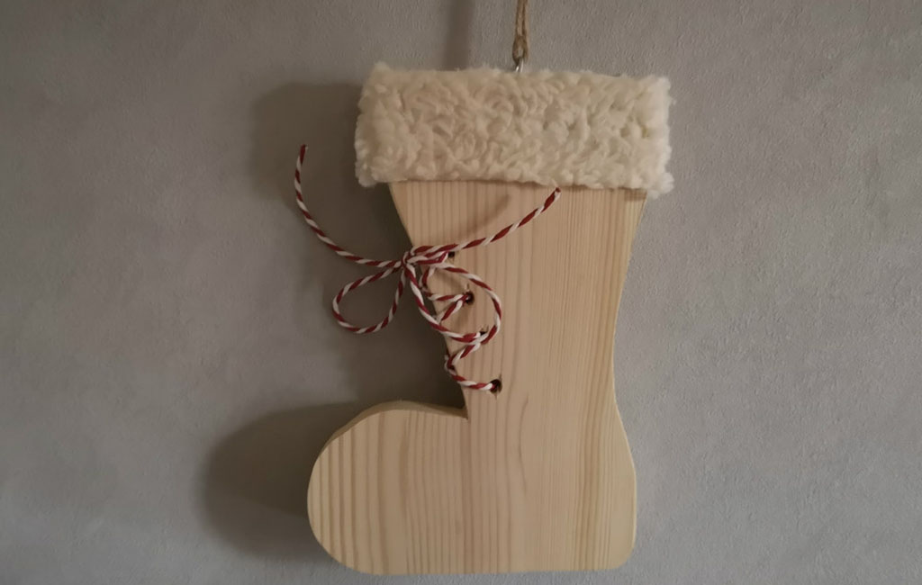 Handmade wooden Christmas stocking decoration with a soft fabric cuff and decorative string