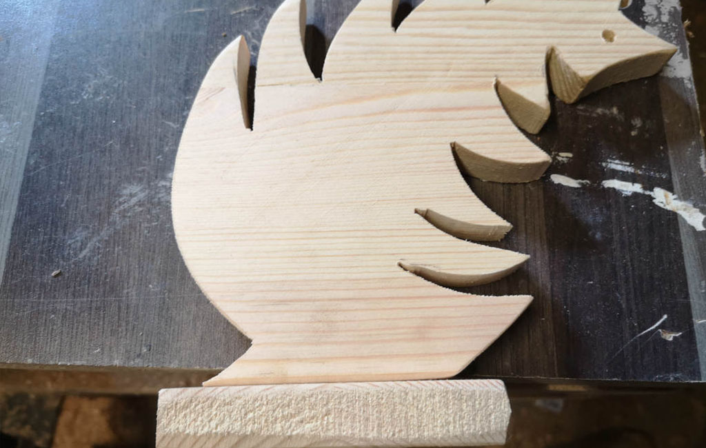 Positioning a small wooden tree on a larger wooden base