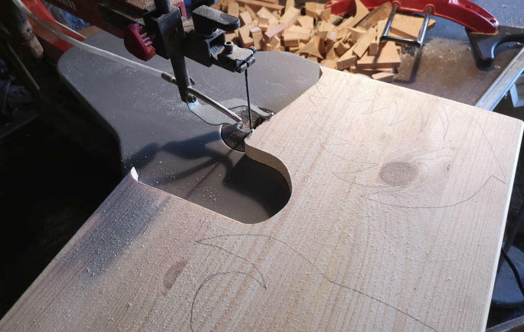 Using a power drill to make a hole in a wooden plank for a DIY Christmas decoration project
