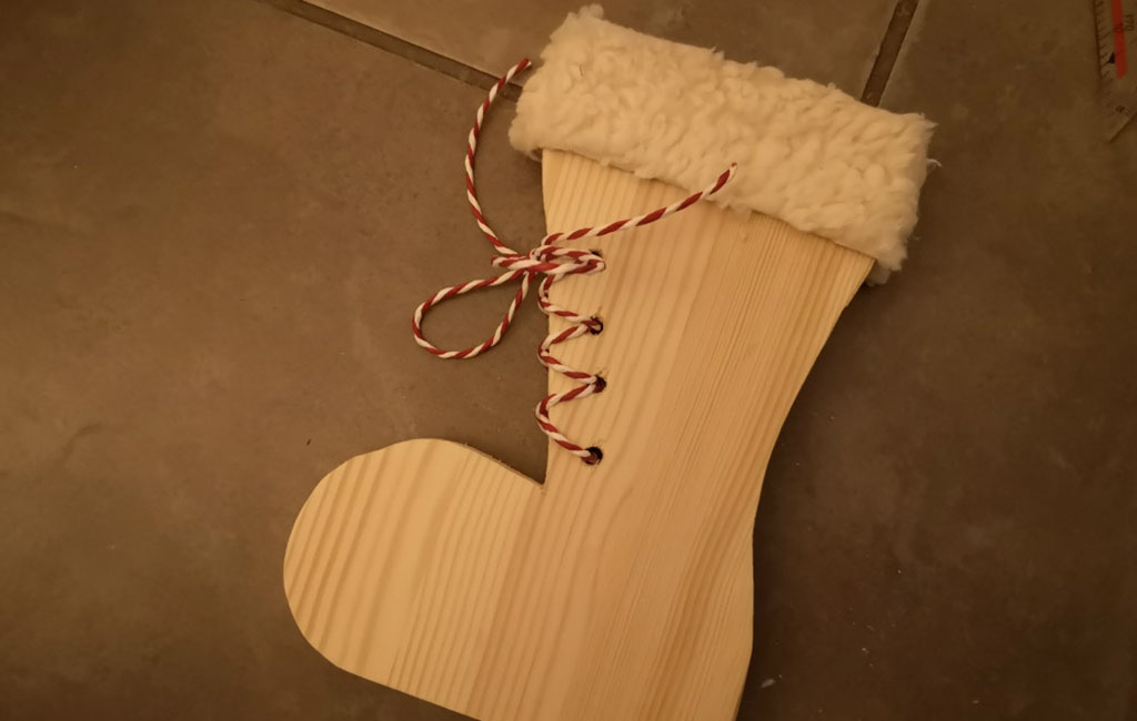 Wooden Christmas stocking decorated with twine and a soft fabric cuff