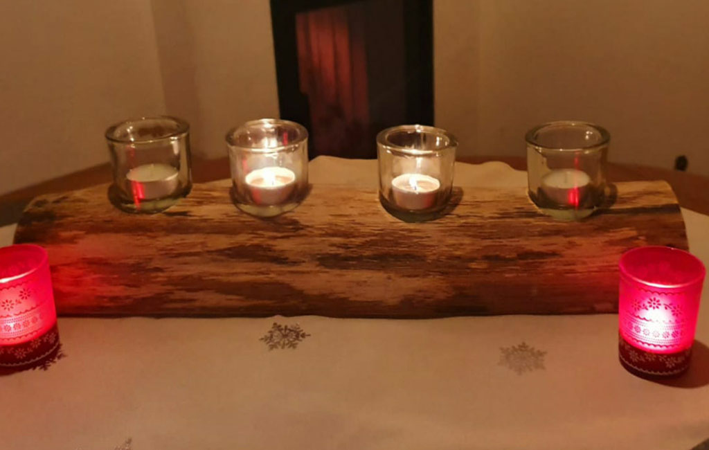 Finished DIY wooden candle holder decoration with lit candles for Christmas ambiance
