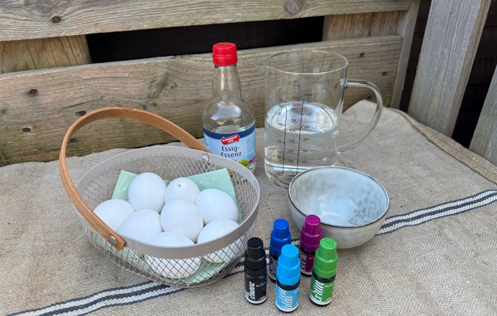 Eggs, vinegar essence, water, bowl and colors prepared on a table.