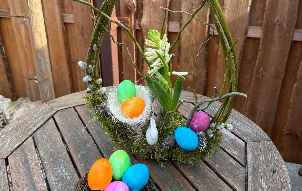 Close-up of the Easter wreath with colorful eggs, moss and flowers.