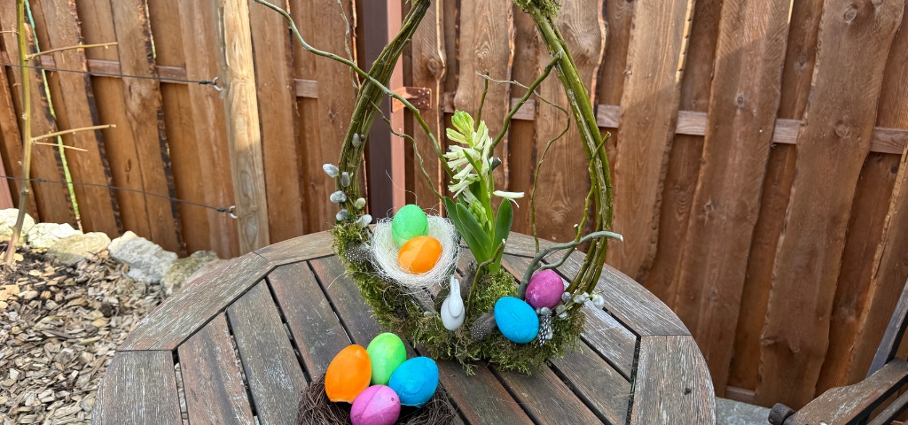 Close-up of the Easter wreath with colorful eggs, moss and flowers.