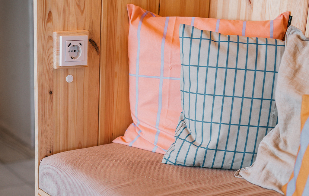 Nahaufnahme einer Steckdose mit Holzrahmen im Innenraum des Strandkorbs.