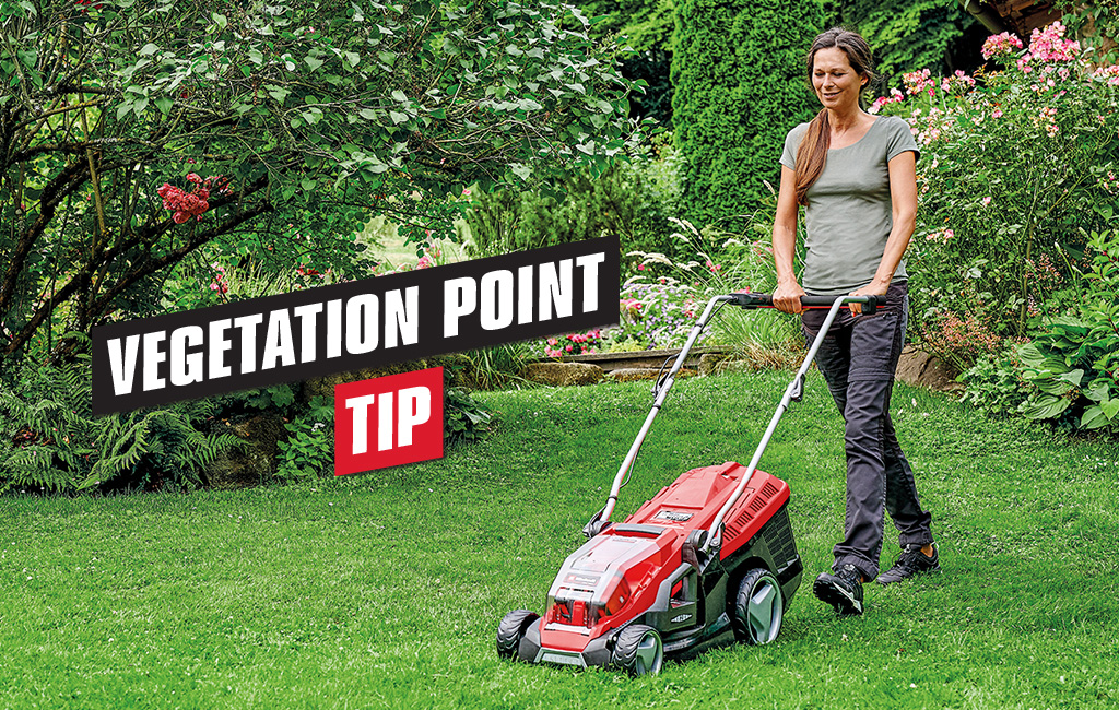 A woman mows the lawn in a garden. Text in the foreground: Vegetation point - Tip