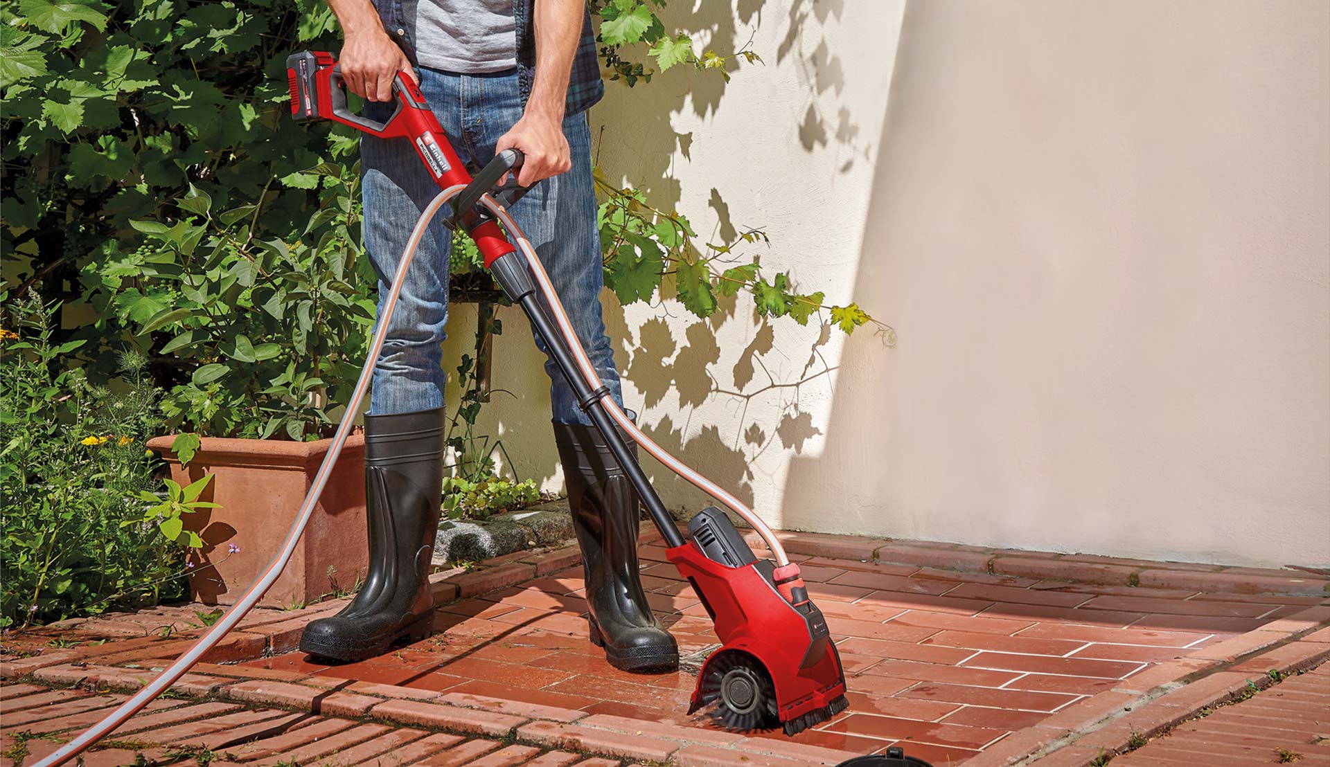 A terrace is cleaned with an Einhell surface brush