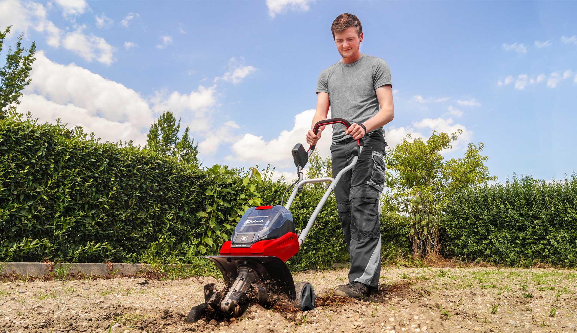 A man is digging up soil with a tiller
