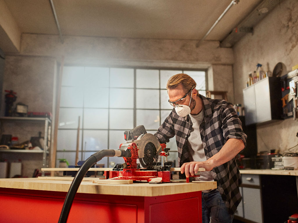 a man cuts a beam with a table saw