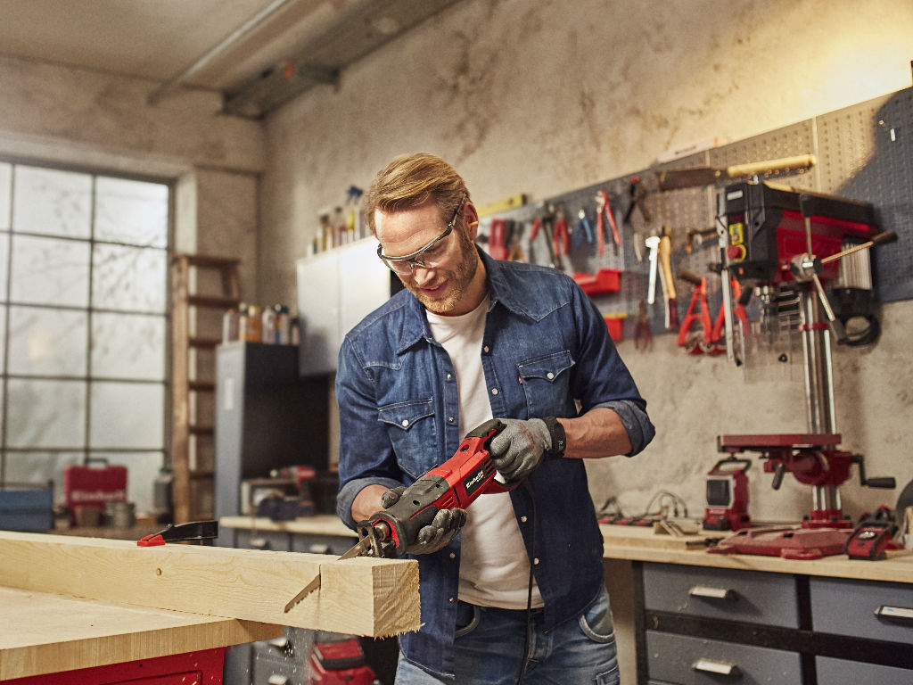 a man cuts a wooden beam