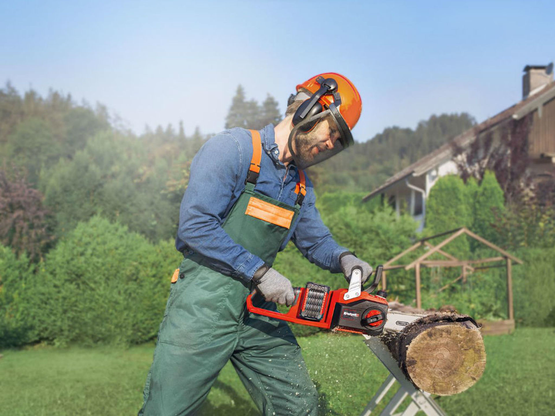 a man saws tree trunk with a chainsaw
