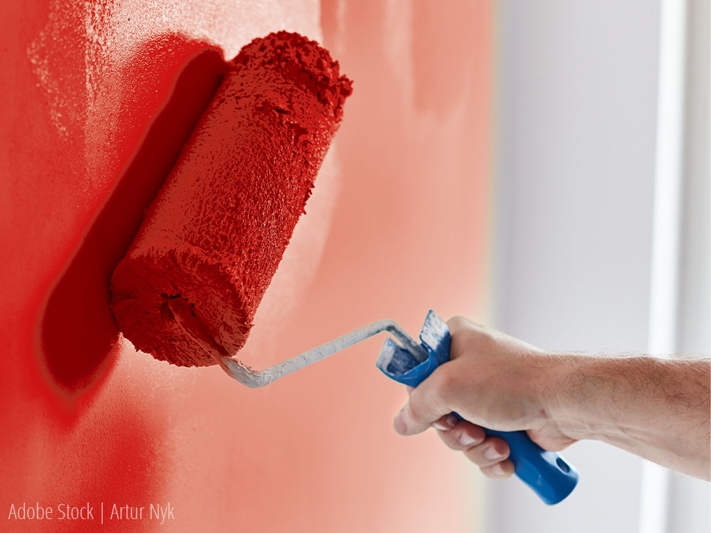 Wand wird mit Farbrolle rot gestrichen