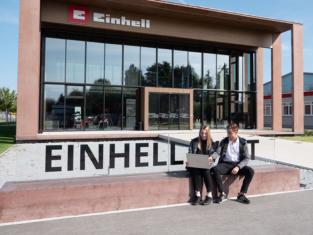 a woman and a man in front of the einhell world