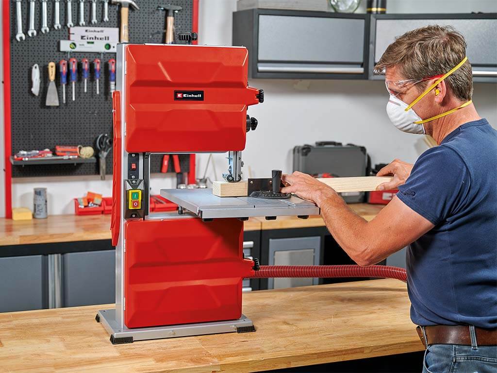 A man cuts a piece of wood with a jigsaw