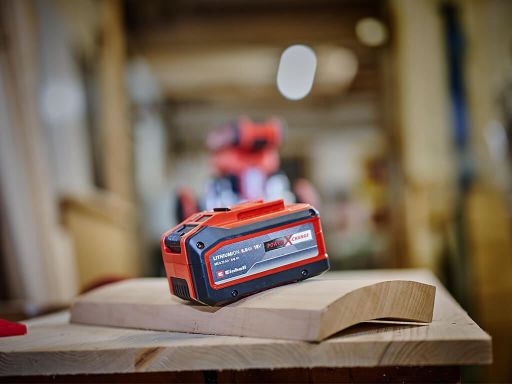 A Power X-Change Multi-Ah battery lying on a workbench