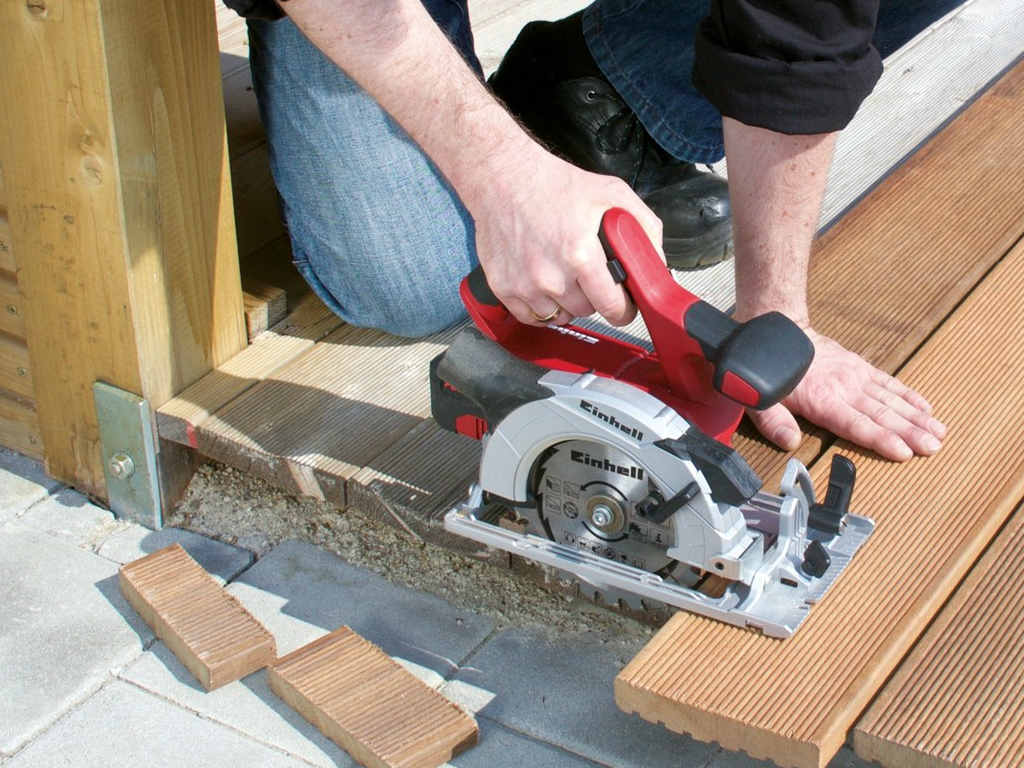 a man cuts a piece of wood with a circular saw