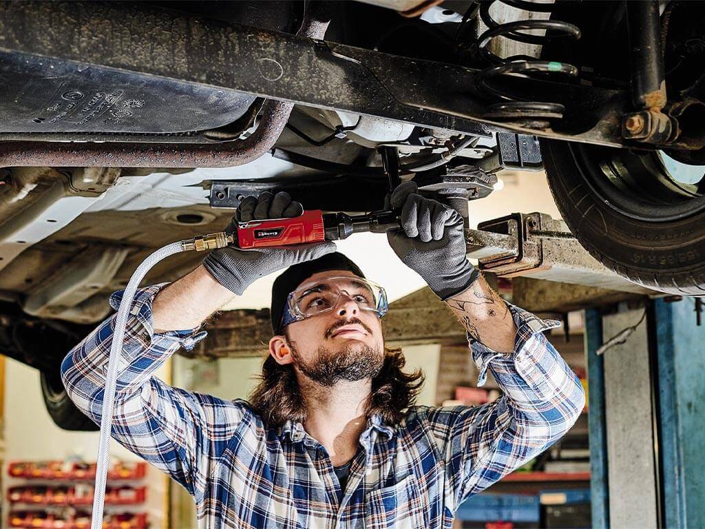 a man repairs a car from below