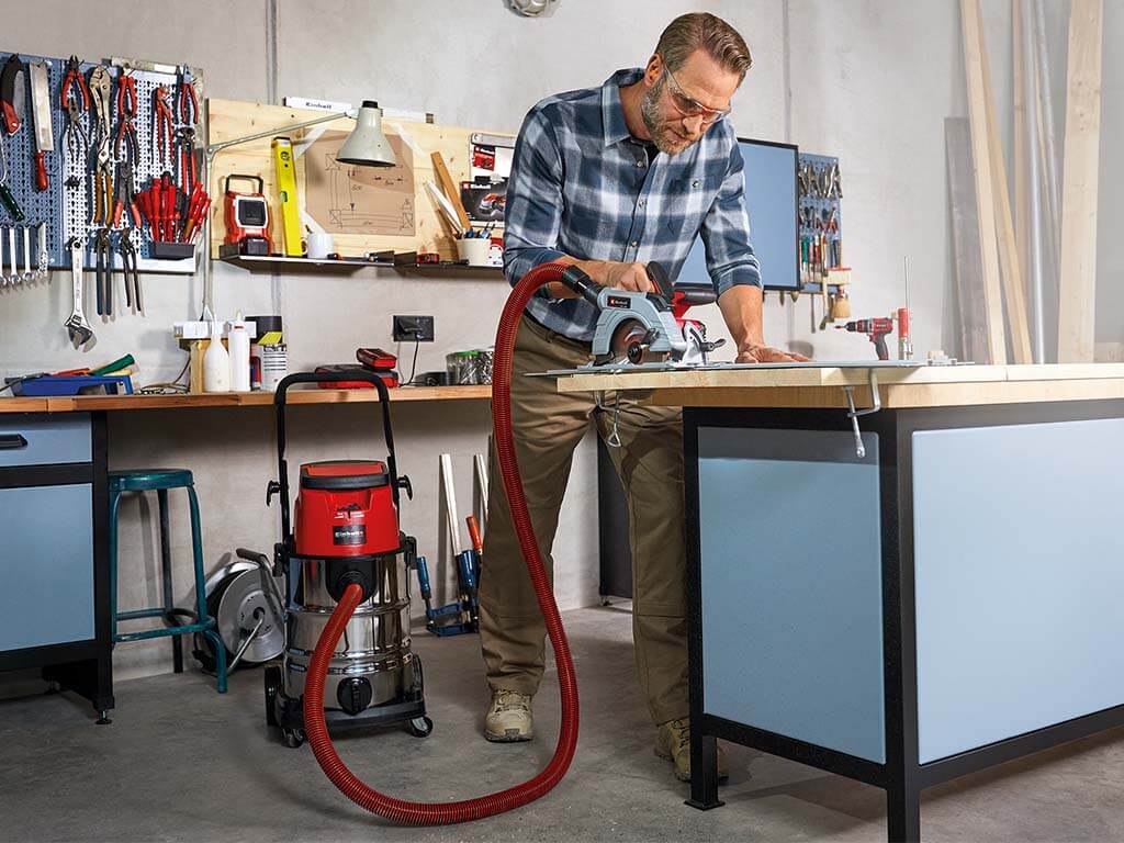 man cuts wood piece with hand circular saw