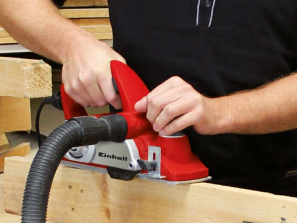 a man planes off a wooden board
