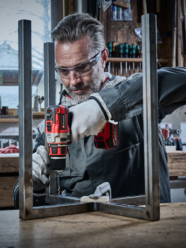 Craftsman drilling a hole into a metal profile with an Einhell drill.