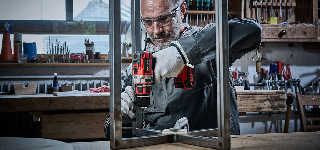 Craftsman drilling a hole into a metal profile with an Einhell drill.