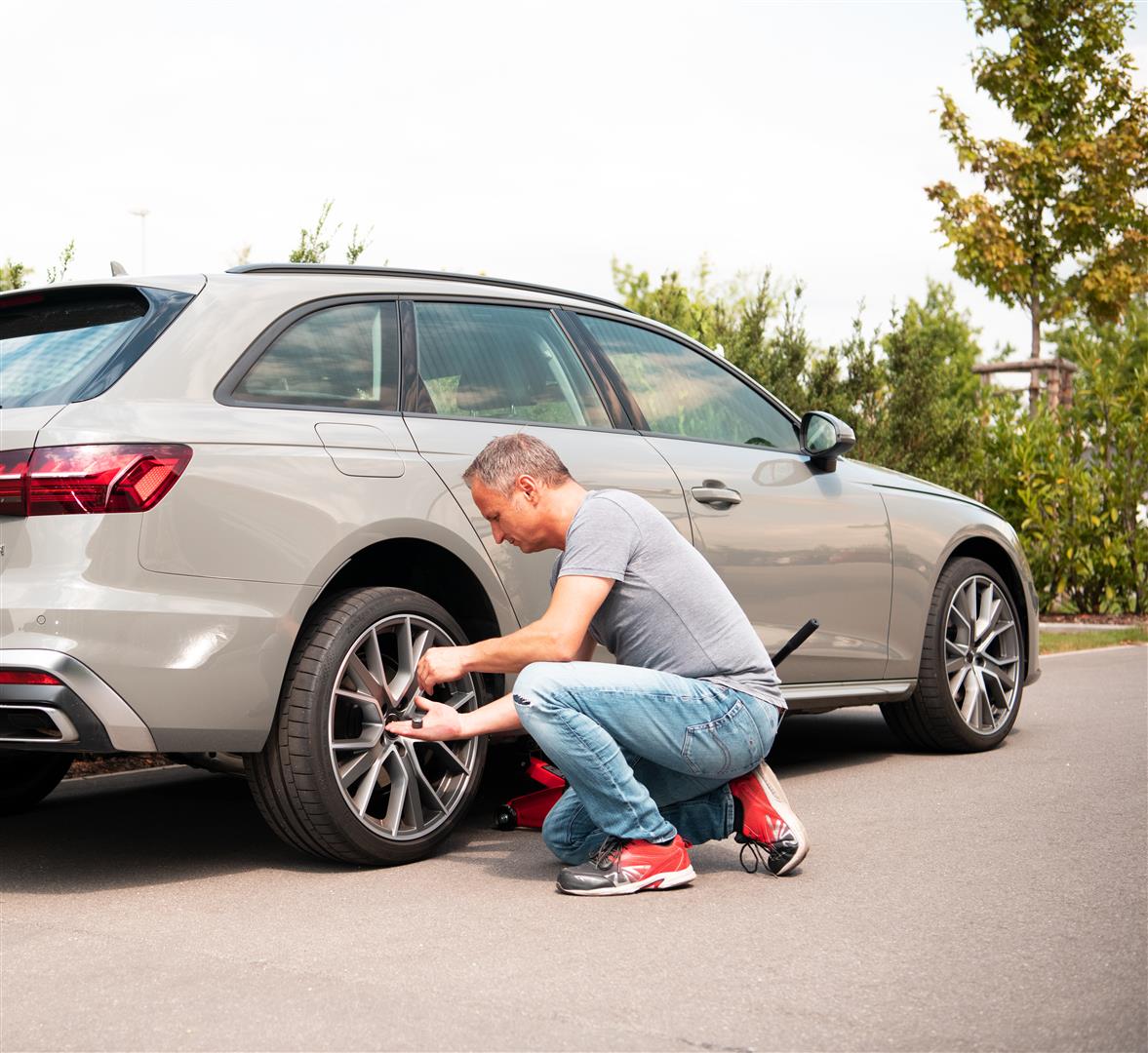  a man fixes his car tire