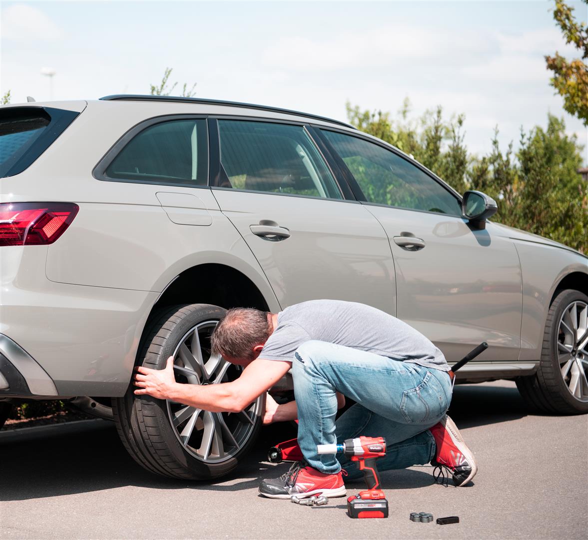 man loosens the screws of his car