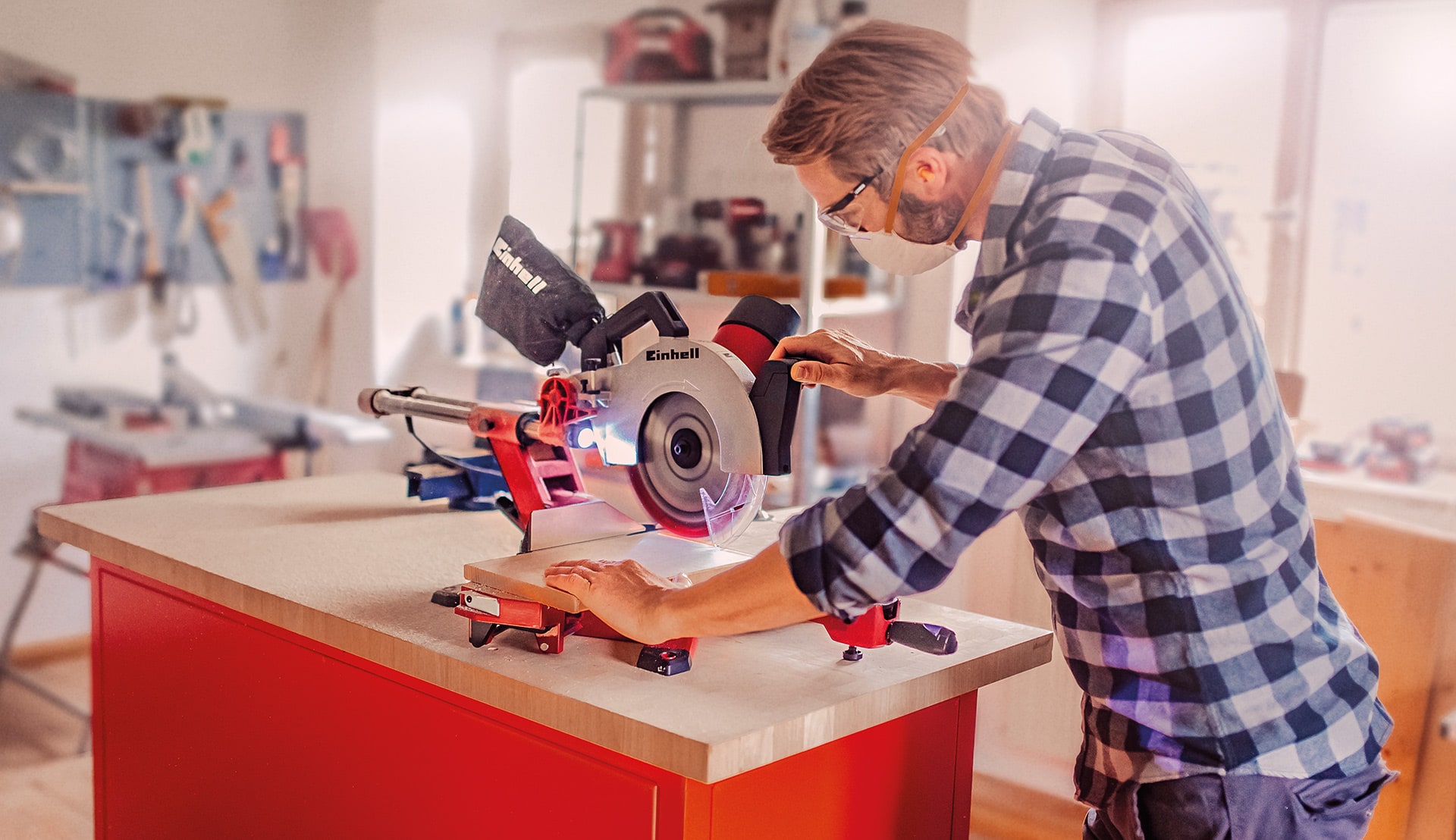 man using mitre saw in a workshop