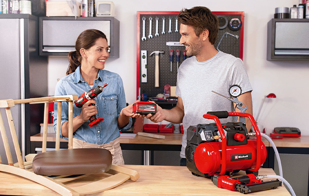 A woman and a man are in a workshop, discussing the Einhell Multi-Ah battery