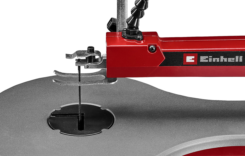 Close-up of the saw blade and holder of the Einhell scroll saw on the grey saw table.