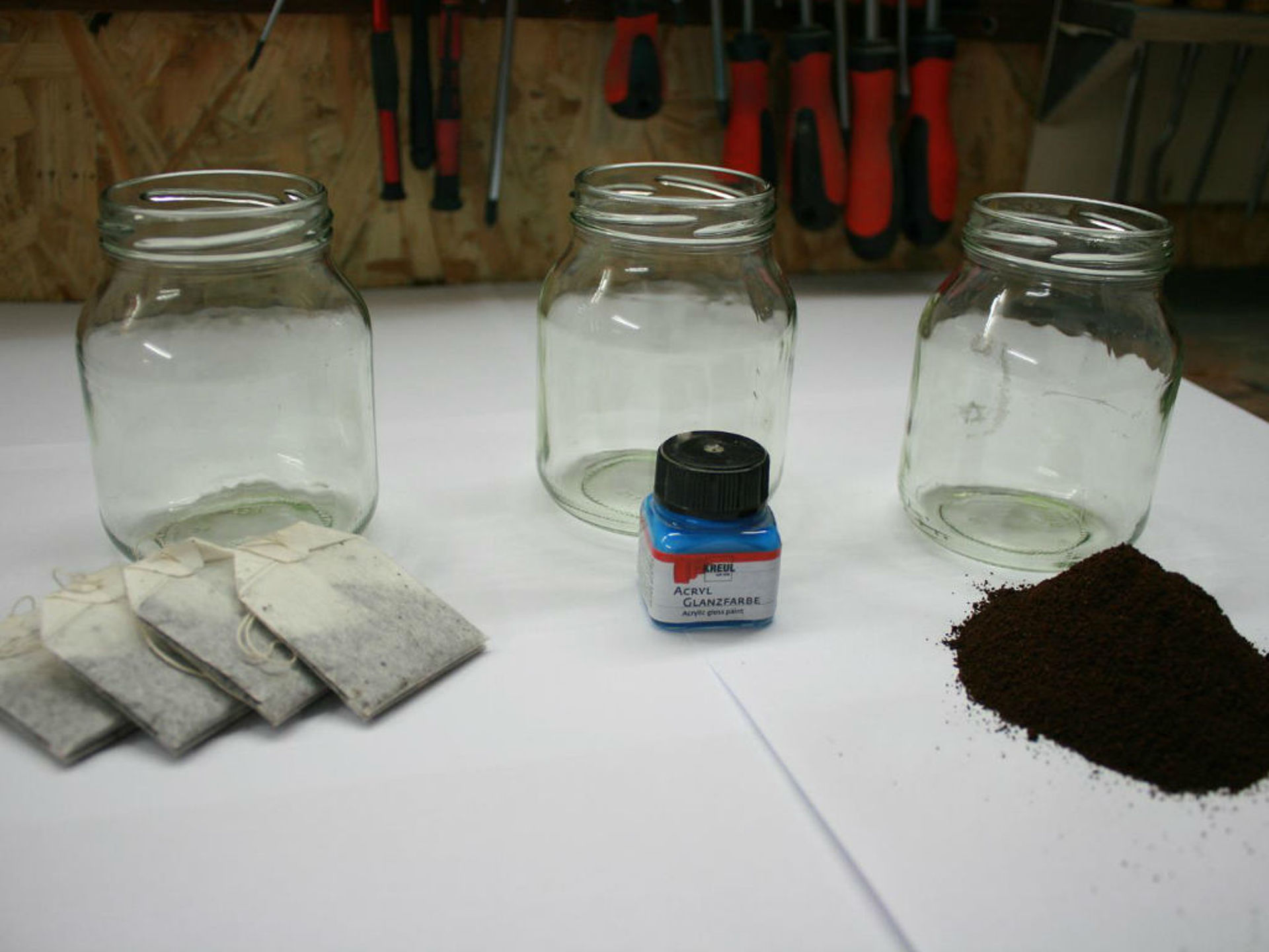 te bag of paint and powder each stand in front of a glass