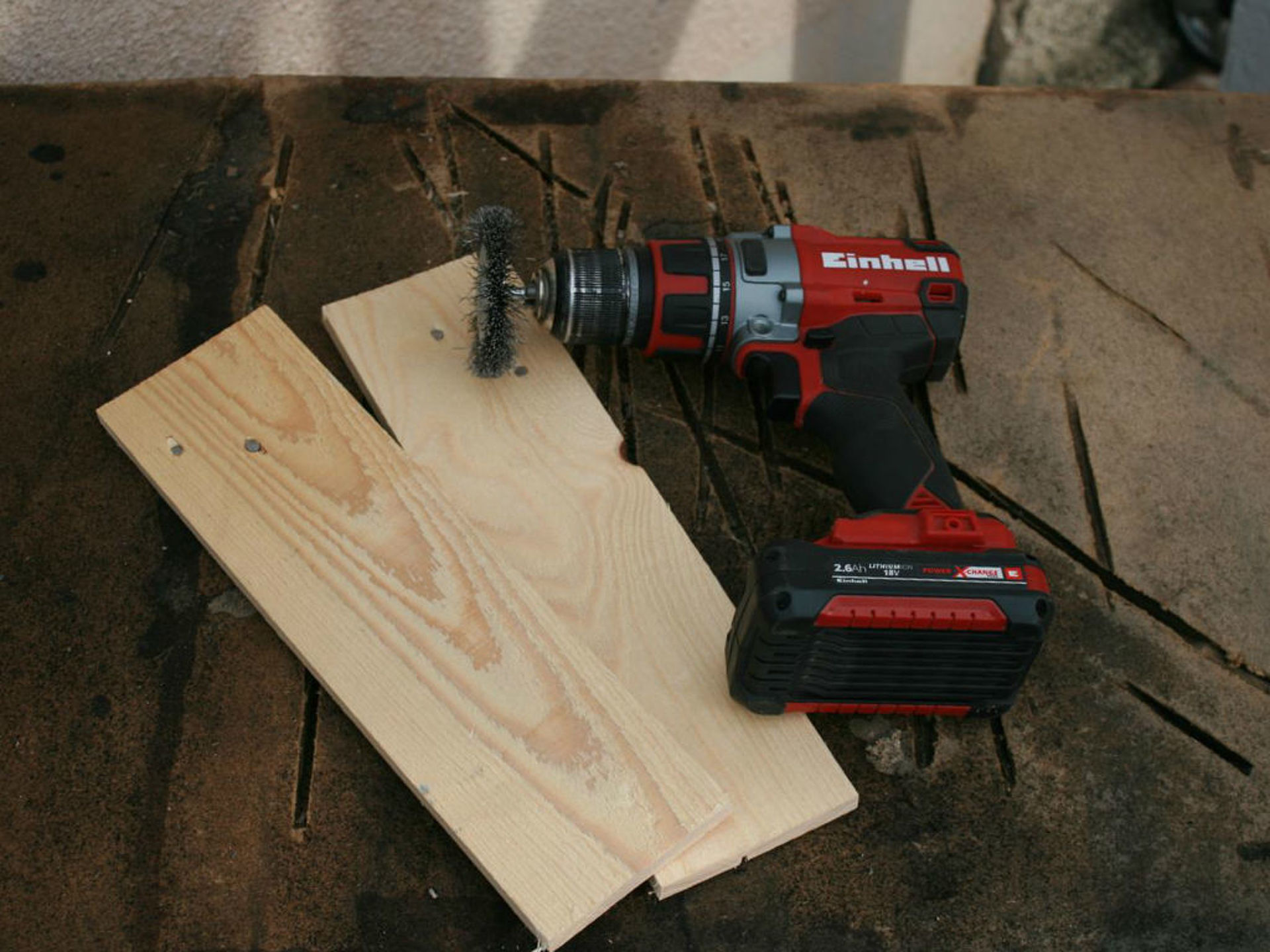 two wooden boards lay on the floor next to brush