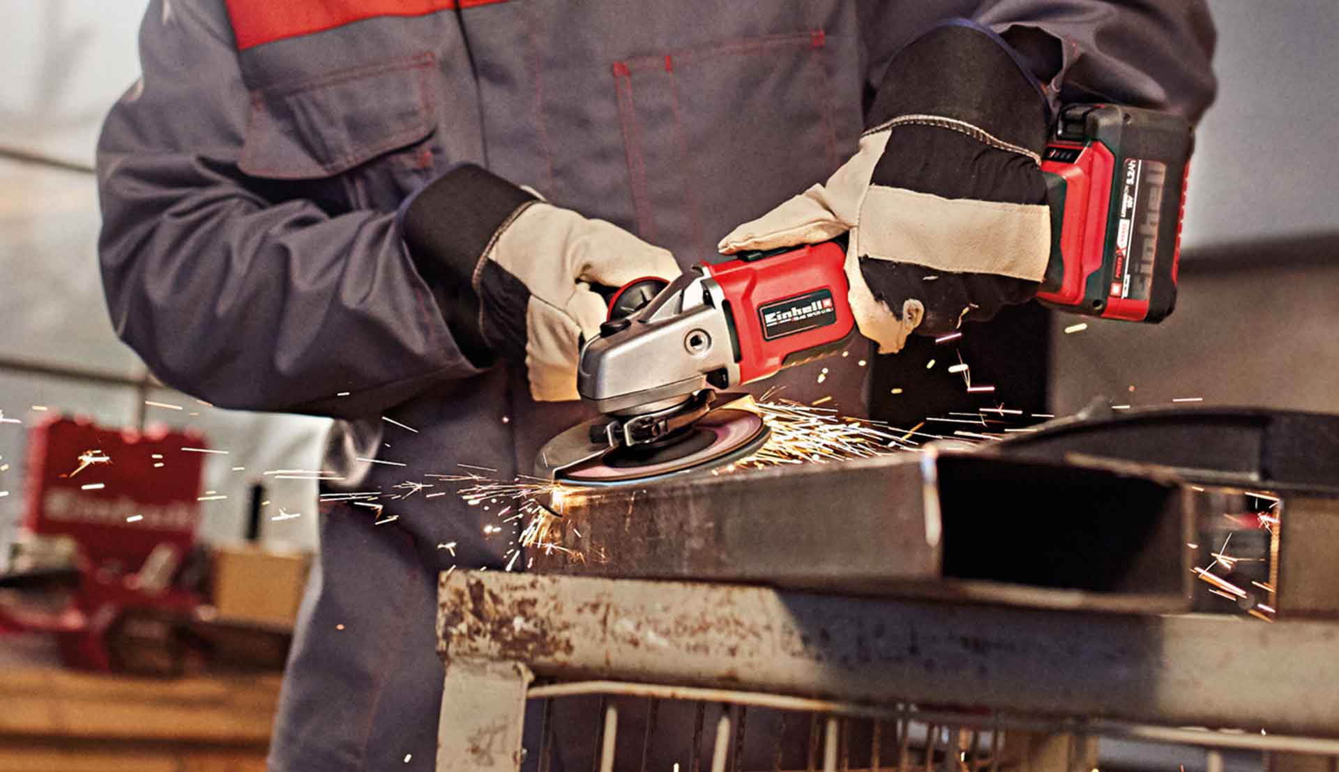 ein Mann arbeitet mit einem Einhell Winkelschleifer in einer Werkstatt