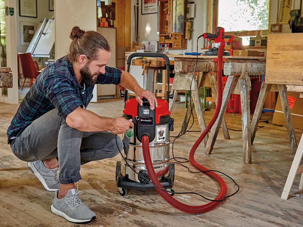 Man with a vacuum cleaner plug and its plug in hand