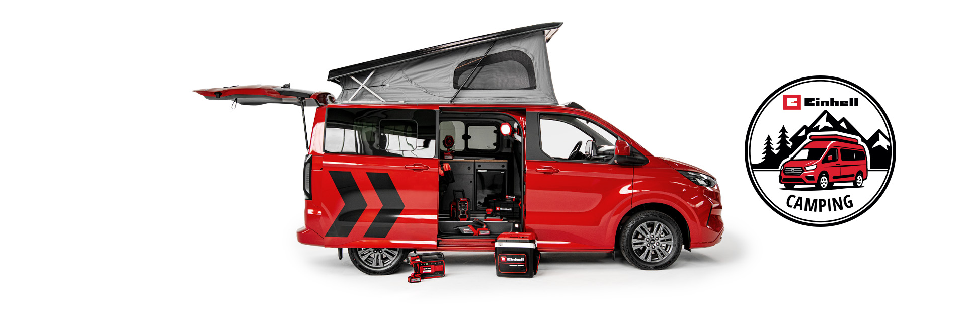 Ein roter Camping-Van mit aufgeklapptem Dach und geöffneten Türen steht auf weißem Hintergrund. Davor sind mehrere Einhell Akku-Geräte platziert. Rechts ist das Einhell-Camping-Logo mit Van und Bergen zu sehen.