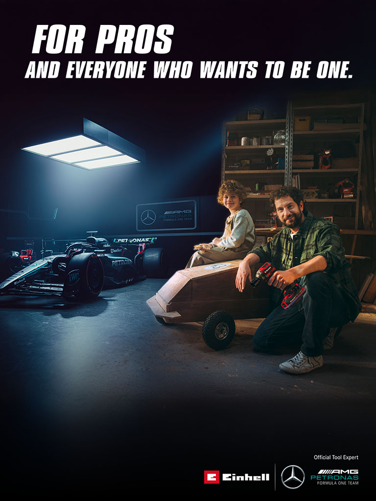 A father and child in a workshop with a homemade soapbox car. In the background, a Mercedes-AMG PETRONAS Formula One car and Einhell tools. Text on the right reads: "For professionals and those who want to become one."