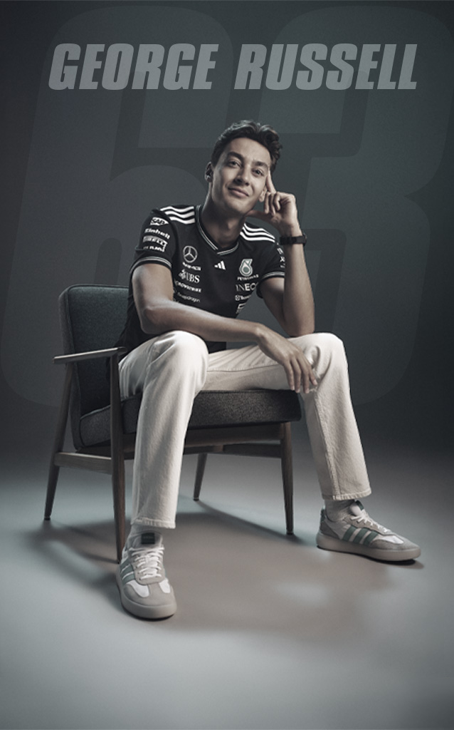 Formula 1 driver George Russell sits relaxed in a chair, with his name displayed in large text behind him against a dark background.