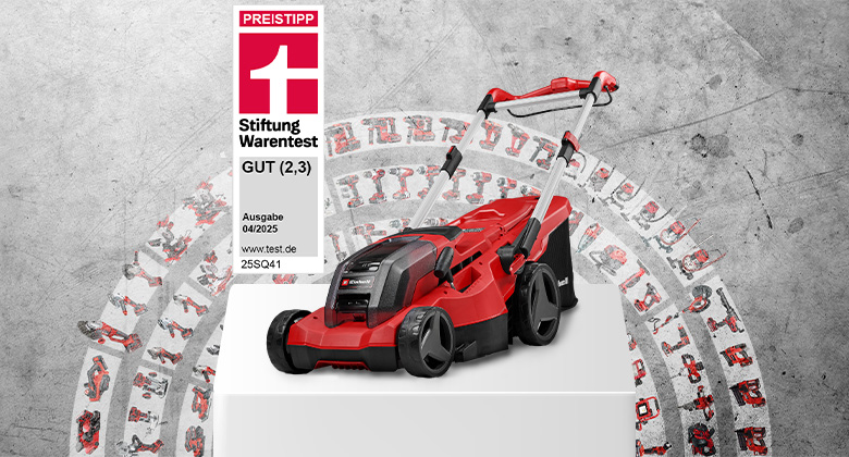 Ein Einhell Akku-Rasenmäher GP-CM 36/450 steht auf einem weißen Podest vor Betonwand. Links daneben ein Testsiegel von Stiftung Warentest: GUT (2,3), Ausgabe 04/2025, 25SQ41. Im Hintergrund sind viele kompatible Geräte aus dem Power X-Change System kreisförmig dargestellt.