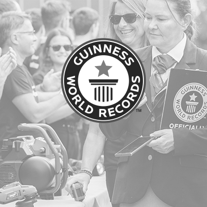 Schwarz-weiß Foto: Das Guinness World Records Logo über einem Event-Foto mit Einhell-Werkzeugen.