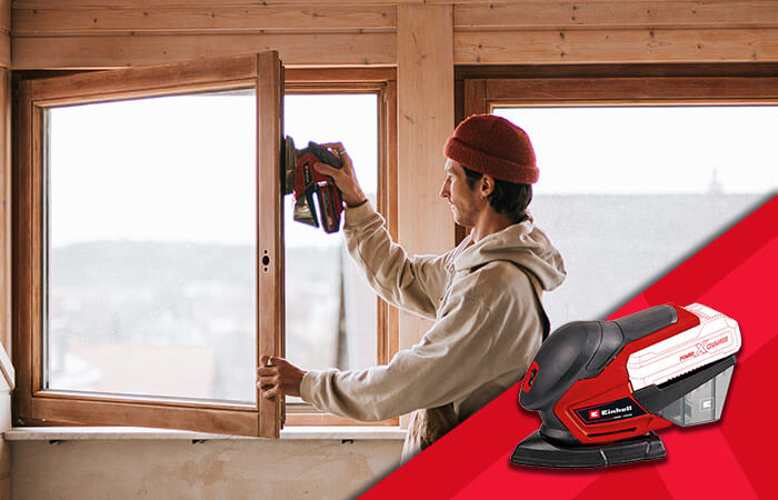 man sands a window with the battery-operated multisander