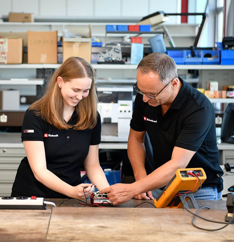 Two people trying out an Einhell product.