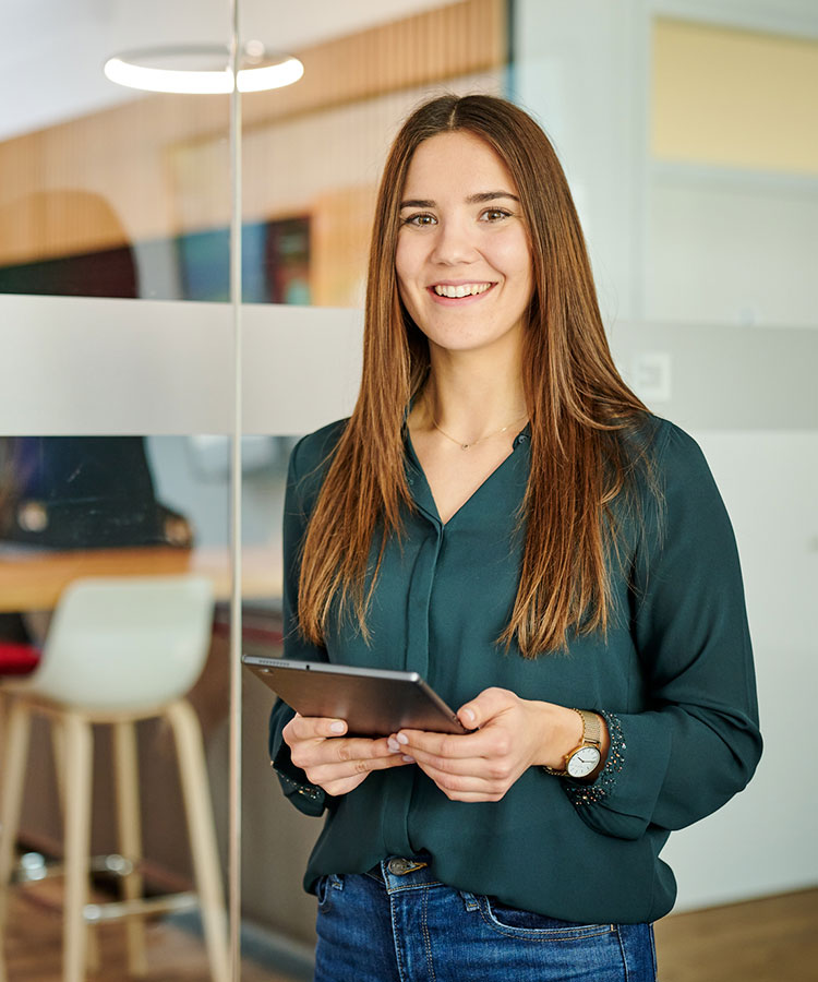 a woman holds a tablet in her hand, smiling