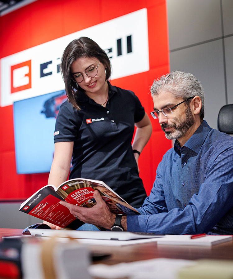 a man looks at a catalog with a woman