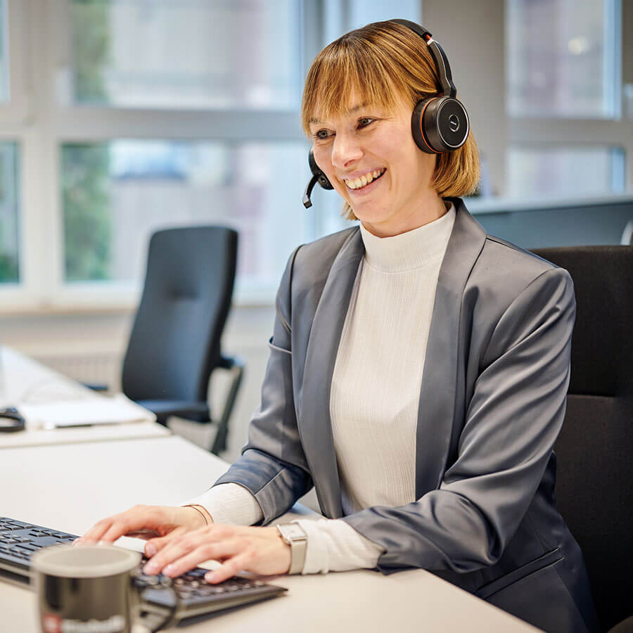 a woman sits at the table with headphones