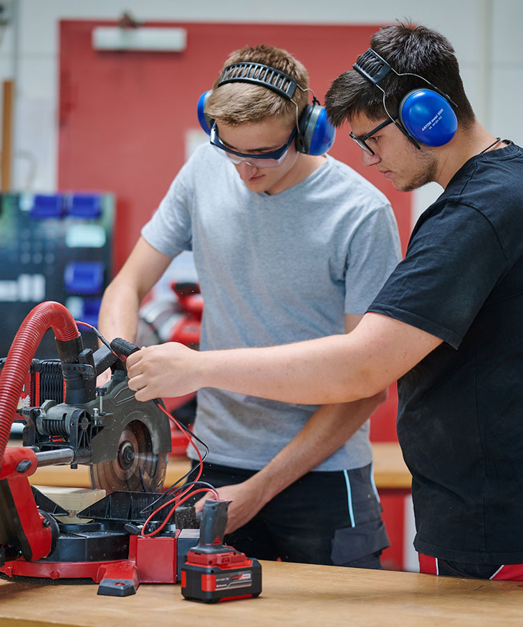two boys cutting on a table saw