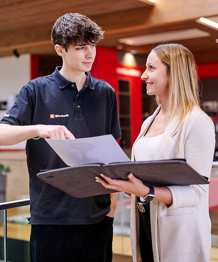 A woman and a man look at a cordless screwdriver on a piece of paper