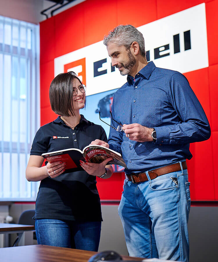 A woman and a man look at a catalog